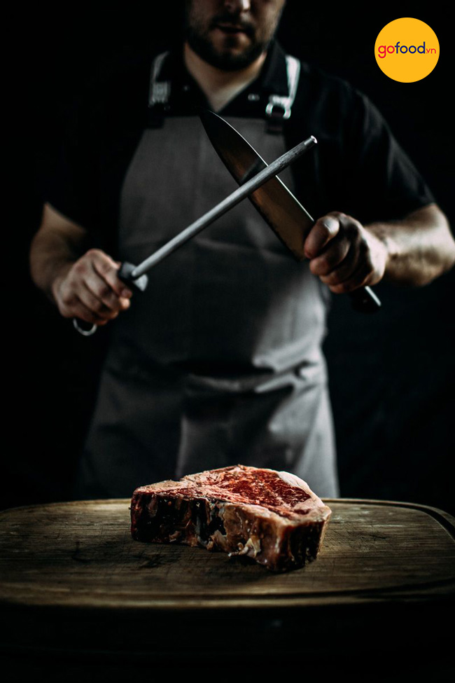 Đầu bếp cắt gọt miếng thịt trước khi gửi tới khách hàng