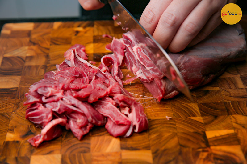 Cắt phần thịt bắp bò thành lát mỏng cho món lẩu