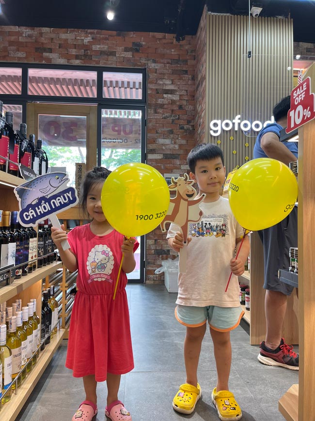 2 vị khách hàng nhí của Gofood Hàm Nghi chụp ảnh tại cửa hàng